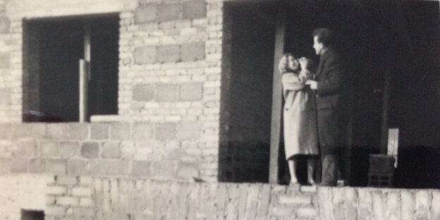 Eine Frau und ein Mann stehen im Rohbau eines Hauses