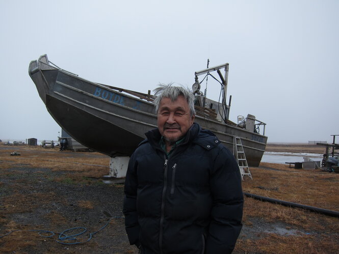 Edgar Jackson steht vor einem Boot, dahinter das Meer