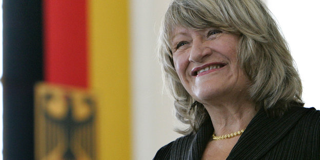 eine grinsende Frau neben einer Deutschlandfahne