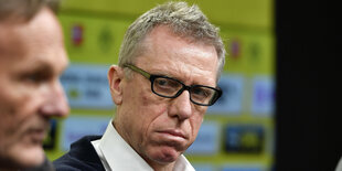 Peter Stöger auf einer Pressekonferenz verzieht den Mund