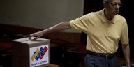 Ein Mann wirft einen Zettel in eine Wahlurne