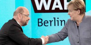Angela Merkel und Martin Schulz schütteln sich die Hände
