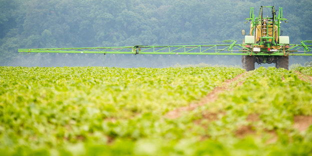 Ein Traktor sprüht Herbizide auf ein Feld