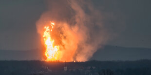 Feuerball über einem Dorf in der Dämmerung