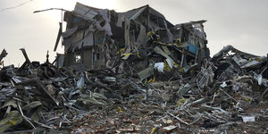 Die Fassade eines zerstörten Hauses auf anderen Trümmern