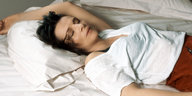 Eine Frau liegt schlafend auf einem Bett
