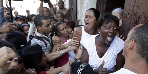 Zwei Frauen in Weiß werden von Unterstüzern des kubanischen Regimes bedrängt