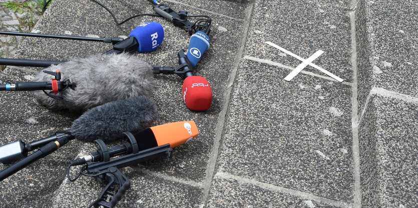 Mehrere Mikrofone liegen auf den Stufen einer Steintreppe im Freien