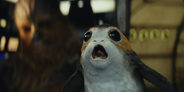 Ein schreiendes Porg, im HIntergrund Chewbacca Ein schreiendes Porg, im HIntergrund Chewbacca