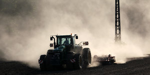 Traktor, eingehüllt in eine Staubwolke