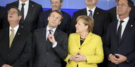 Der Präsident von Zypern, Nicos Anastasiades, der französische Präsident Emmanuel Macron und Bundeskanzlerin Angela Merkel (in gelb) blicken während eines Gruppenfotos im Rahmen des EU-Gipfels nach oben