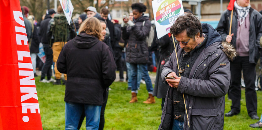 Ein Mann auf einer Kundgebung schaut auf sein Telefon