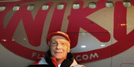 ein Mann steht neben einem Flugzeug, auf dem „Niki“ steht