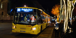 Ein als Weihnachtsmann verkleideter Busfahrer der Berliner Verkehrsbetriebe winkt am 07.12.2017 in Berlin Passanten und Touristen von seinem Fahrerarbeitsplatz aus zu