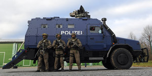 Bewaffnete Polizisten des SEK stehen vor dem Panzerwagen "Survivor R"