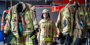 Porträt Rolf-Dieter Erbe in Uniform zwischen aufgehängten Uniformen