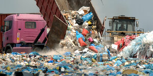 ein Kipplaster lädt Müll auf Deponie einer ab