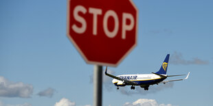 Ein Flugzeug fliegt hinter einem Stoppschild