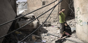 Ein Paar macht Pause auf der Flucht in einem zerstörten Viertel von Mossul