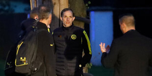 Der frühere BVB-Trainer Thomas Tuchel und Sicherheitsleute stehen nach dem Anschlag ratlos vor dem Bus von Borussia Dortmund