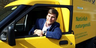 Ein Mann sitzt in einem Elektro-Postauto, es ist Achim Kampker