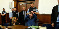 Ein Justizvollzugsbeamter nimmt dem Angeklagten Sergej W. die Handschellen ab.