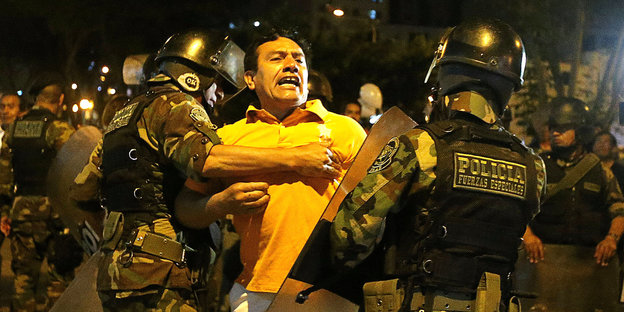 Wütender Mann wird von uniformierten Polizisten festgehalten