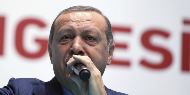 Der türkische Präsident Erdogan spricht in ein Mikrofon