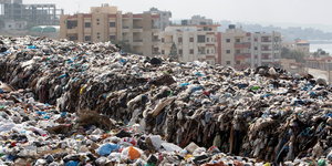 Müllberge in Jiiyeh, im Hintergrund Hochhäuser und Meer