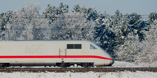 ein ICE fährt durch eine verschneite Landschaft