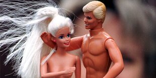 Ken und Barbie mit nackten Oberkörpern vor dem Gesicht eines Kindes