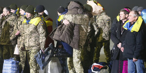 Verwandte umarmen die freigelassenen Gefangenen am Flughafen in Kiew