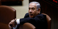 benjamin Netanjahu sitzt zwischen braunen Sesseln, einen Arm auf der Lehne vor sich abgestützt