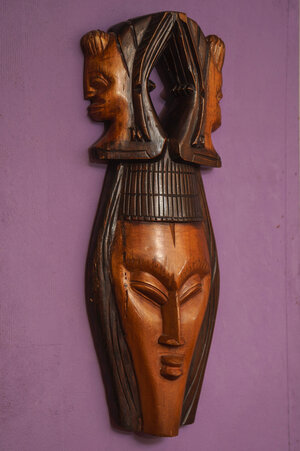 Eine afrikanische Holzmaske hängt an einer Wand Eine afrikanische Holzmaske hängt an einer Wand