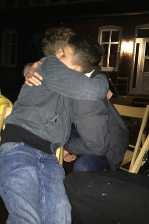 Zwei Jungs umarmen sich am Lagerfeuer