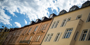 Reihenhäuser und der Himmel mit Wolken, durch die die Sonne scheint