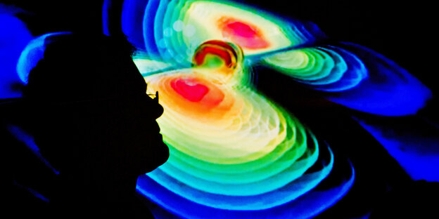 Umriss eines Mannes vor der grafischen Darstellung von Gravitationswellen