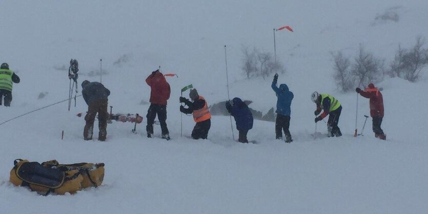 Menschen suchen im Tiefschnee