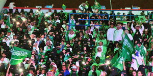 eine Menschenmenge mit vielen saudischen Fahnen