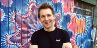 Porträt von Max Schrems vor einem Graffiti