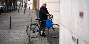 Ein Mann steht neben seinem Fahrrad