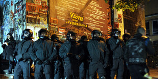 Polizisten mit Helmen und geschlossenem Visier stehen vor der Roten Flora.