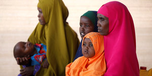 Zwei somalische Frauen mit bunten Kopftüchern und drei kleinen Kindern