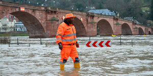 Ein Mann steht im Hochwasser des Neckars bei Heidelberg