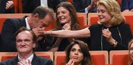 Der Schauspieler Vincent Lindon gibt Catherine Deneuve einen Handkuss. Beide sitzen im Rang eines Theaters