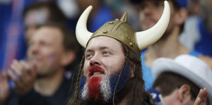 Ein isländischer Fußballfan mit Bart in den Farben der Nationalflagge gefärbt