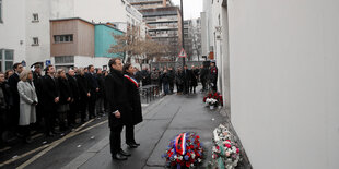 Frankreichs Präsident Emmanuel Macron und die Pariser Bürgermeisterin Anne Hidalgo bei einer Gedenkminute vor dem ehemaligen Haus der Satirezeitschrift Charlie Hebdo.