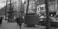 Schwarzweiß Foto des Boulevard des Capucines in Paris mit rundem Pissoir auf dem Trottoir.
