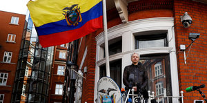 Ein Mann auf einem Balkon, über ihm weht die gelb-blau-rote Flagge von Ecuador