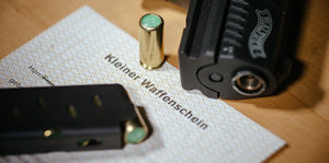 Ein Kleiner Waffenschein liegt zwischen einer Schreckschuss-Pistole «Walther P22», einem Magazin und einer Knallpatrone